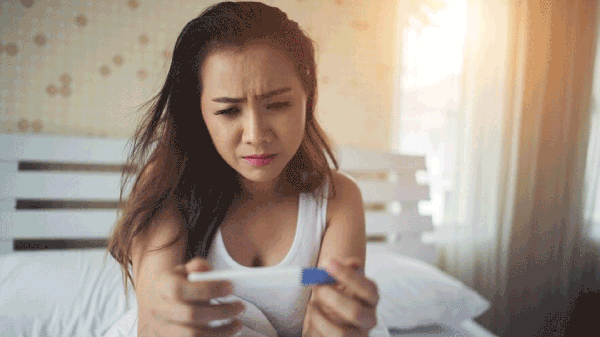 frustrated woman with pcos holding pregnancy test